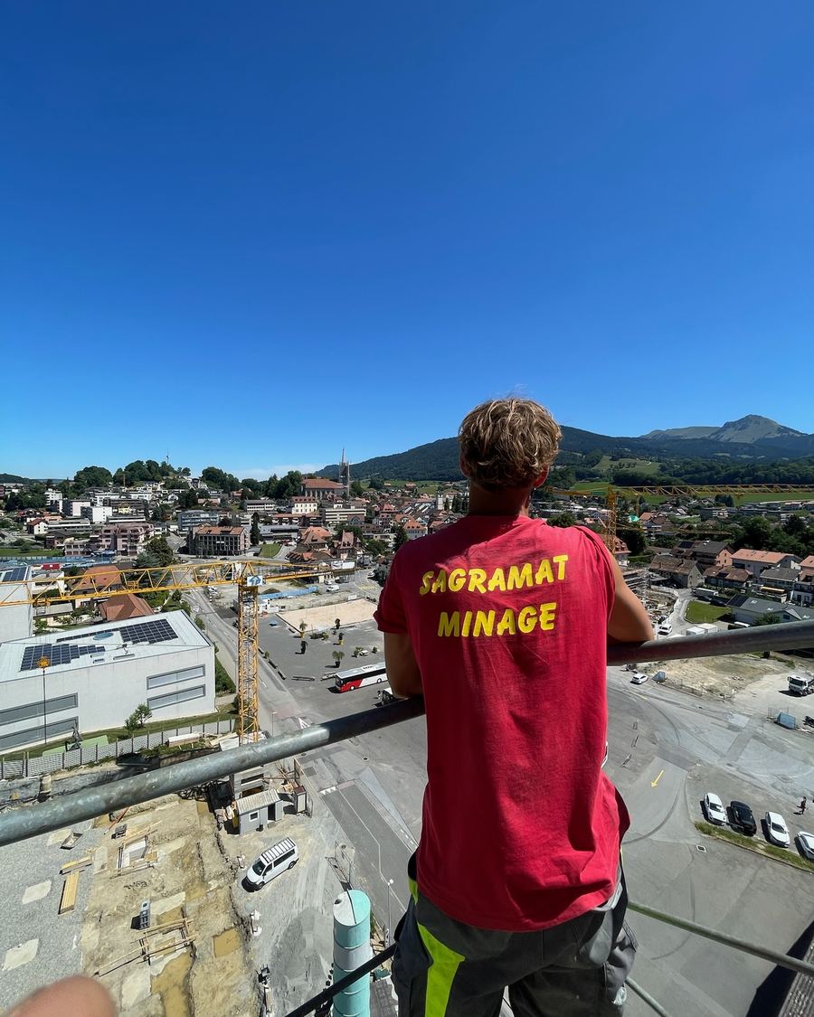 Mineur Sagramat en t-shirt de l'entreprise, face à la ville