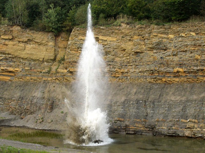 Tir sous l'eau : colonne d'eau projetée dans un plan d'eau de carrière