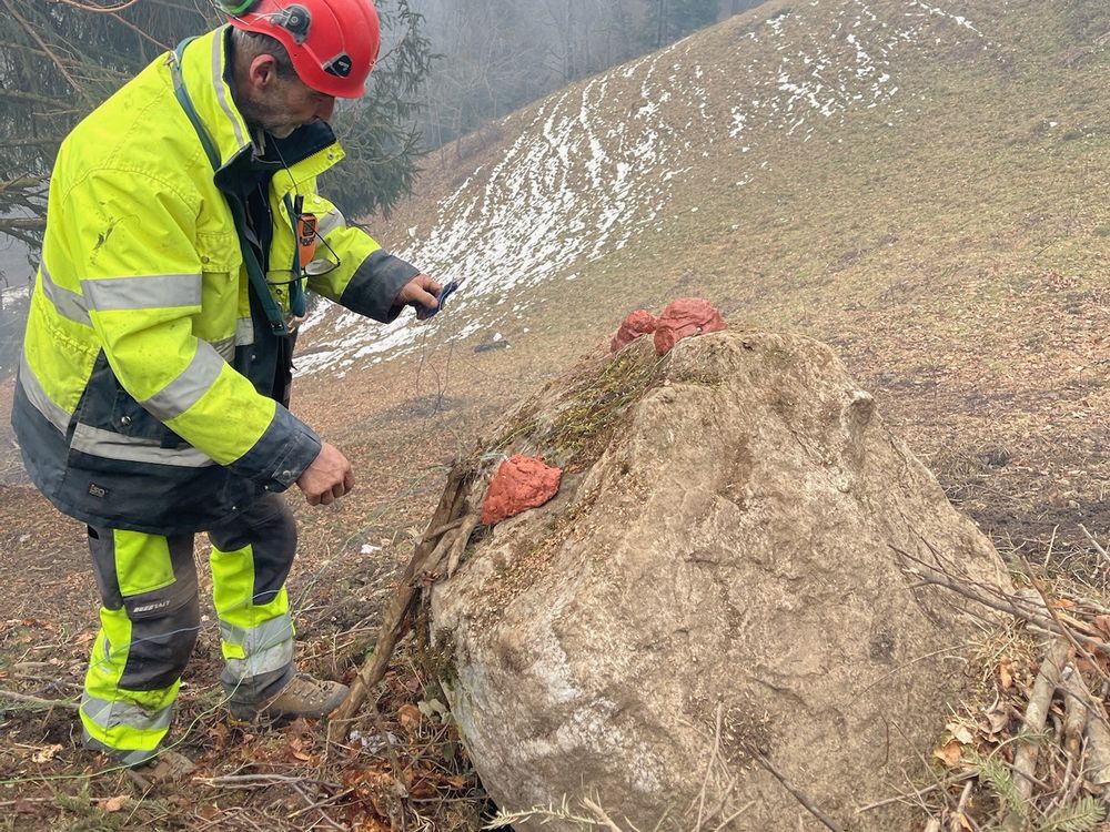 Mineur Sagramat contrôlant les charges posées sur un bloc rocheux en montagne